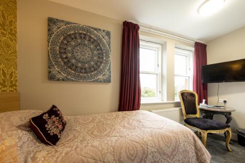 a bedroom with a bed and a chair and a desk at Brockley Hall Hotel in Saltburn-by-the-Sea