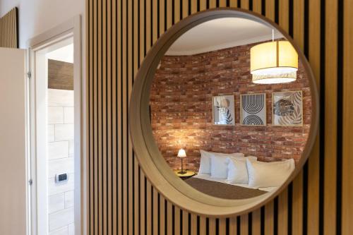 a mirror in a room with a bed and a brick wall at Le Mole B&B in Marino