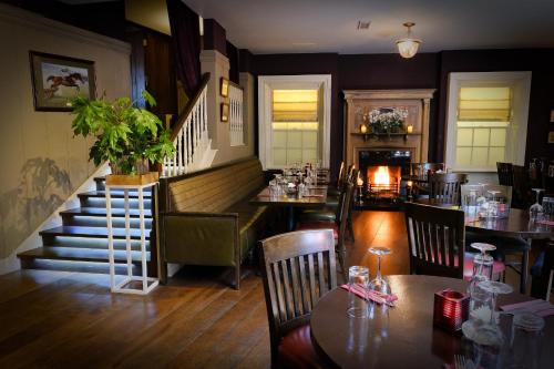 a restaurant with a table and chairs and a staircase at Horse & Hound in Delgany