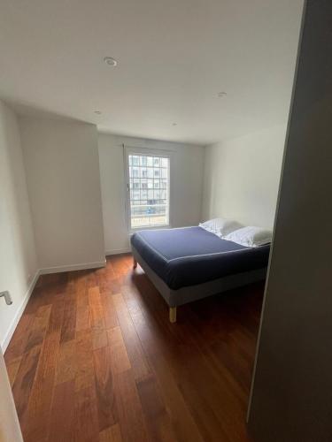 une chambre avec un lit et une fenêtre dans l'établissement Bel appartement Fragonard, à Charenton-le-Pont