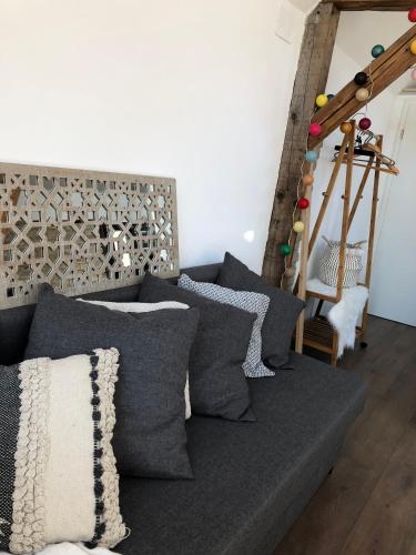 a couch with gray pillows in a living room at My l'ITTle Home in Ittenheim