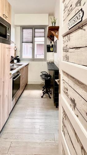 une cuisine avec parquet et une cuisine avec armoires en bois dans l'établissement Toulon T2 4 couchages, à Toulon