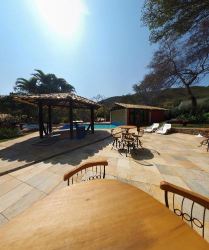 a patio with tables and chairs and a pool at Pousada Varandas da Serra in Serra do Cipo