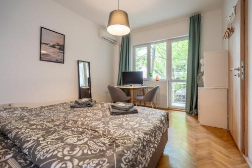a bedroom with a bed and a desk with a computer at Central Sofia Gem by Vitoshka Street in Sofia