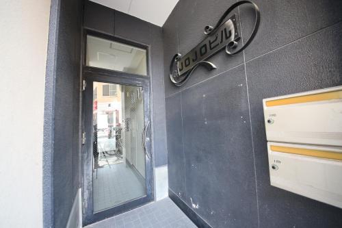 a door to a store with a sign on a wall at goom Monthly Nakasu JOJO in Fukuoka