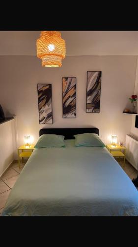 une chambre avec un grand lit avec trois tableaux au mur dans l'établissement Cozy studio in Neuilly-sur-Marne, à Neuilly-sur-Marne