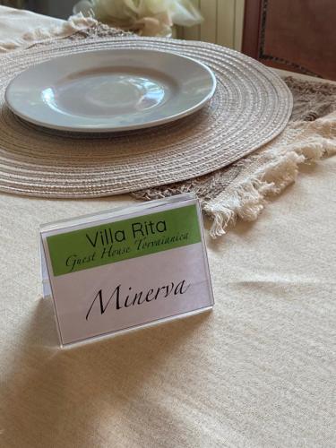a plate sitting on a table with a sign on it at Villa Rita Guest House Torvaianica in Torvaianica