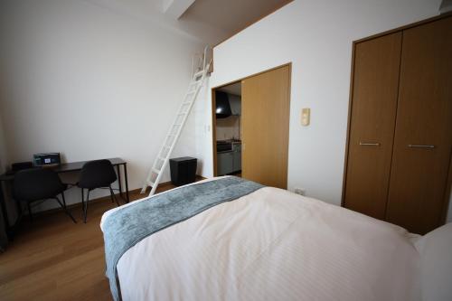 a bedroom with a bed and a ladder on the wall at goom Monthly Nakasu JOJO in Fukuoka
