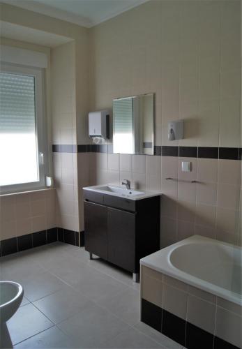 a bathroom with a tub and a sink and a bath tub at O Forte Guest House in Peniche