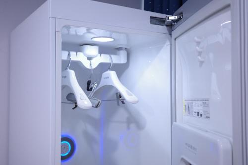 a white cabinet with white hair dryers in a room at Aewol Bada 23 in Jeju