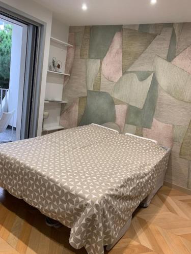 une chambre avec un lit dans une chambre avec un mur dans l'établissement Clinfoc 21, à La Grande Motte