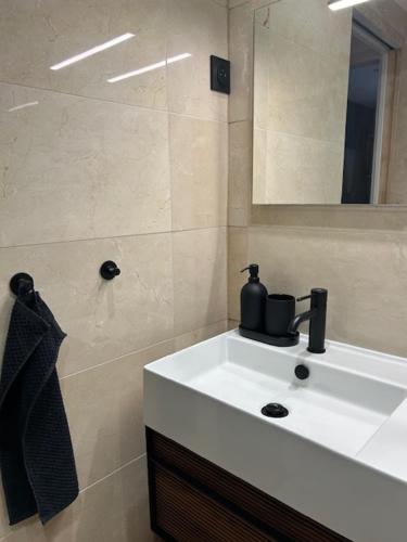 une salle de bain avec un lavabo blanc et un miroir dans l'établissement Clinfoc 21, à La Grande Motte