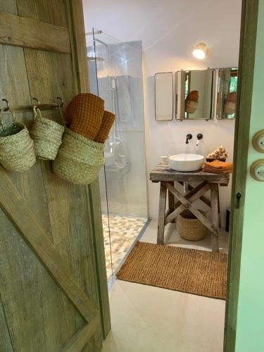 La salle de bains est pourvue d'une douche, d'un lavabo et d'une porte. dans l'établissement La cabane dans les arbres, à Couze-et-Saint-Front
