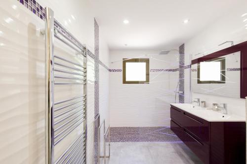 une salle de bain avec une douche en verre et un lavabo dans l'établissement Les terrasses de victoria, au Cannet