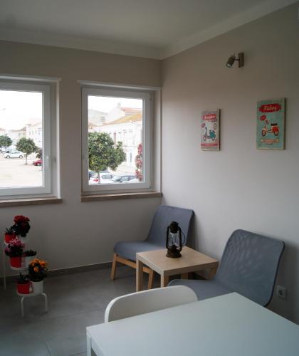 a room with two chairs and a table and two windows at O Forte Guest House in Peniche