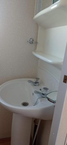 a bathroom with a white sink and a toilet at Beachside, Family-friendly, WiFi, 6 berth Caravan 19 in Ingoldmells in Ingoldmells