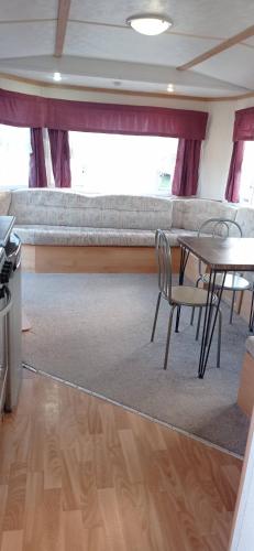 a room with a table and chairs and a couch at Beachside, Family-friendly, WiFi, 6 berth Caravan 19 in Ingoldmells in Ingoldmells