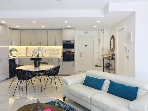 un salon avec un canapé blanc et une table dans l'établissement Apartment La Palmeraie with terrace Golfe Juan, à Vallauris