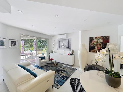 un salon avec un canapé blanc et une table dans l'établissement Apartment La Palmeraie with terrace Golfe Juan, à Vallauris