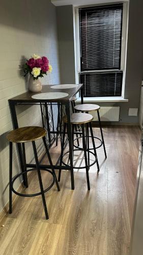 ein Tisch und Stühle mit einer Blumenvase darauf in der Unterkunft Twice Rent in Chişinău