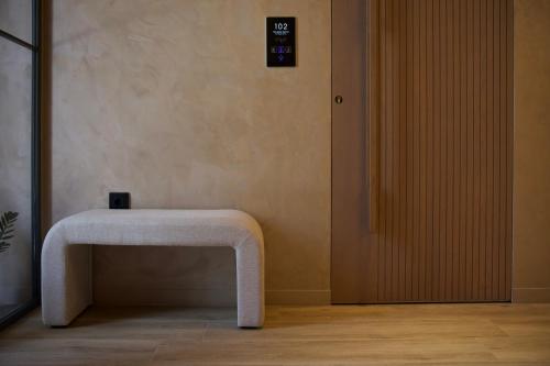 a white bench sitting in a room next to a door at Nearchou Boutique Hotel in Chania Town