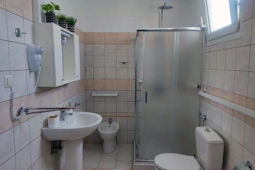a bathroom with a toilet and a sink and a shower at Nikis House in Keramoti