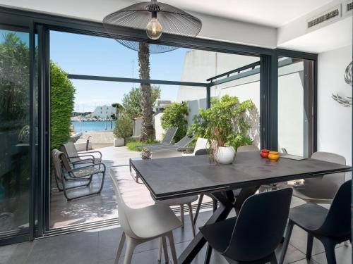 une salle à manger avec une table et des chaises sur un patio dans l'établissement Villa Marina N173 - 5P6, au Grau-du-Roi