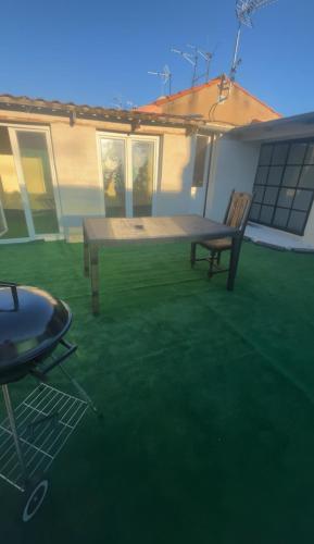 d'une terrasse avec une table en bois et un banc. dans l'établissement Appartement duplex avec terasse centre-ville Béziers, à Béziers