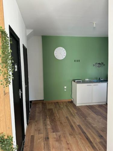 une chambre dotée d'un mur vert avec une horloge. dans l'établissement Appartement duplex avec terasse centre-ville Béziers, à Béziers