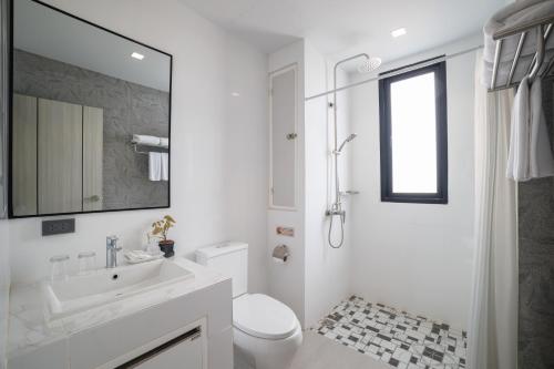 a white bathroom with a sink and a toilet at The Horizon Groove Hotel in Ban Khlong
