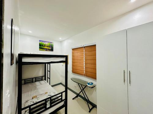 a bedroom with a bunk bed and a desk at Rai Staycation in Sampong