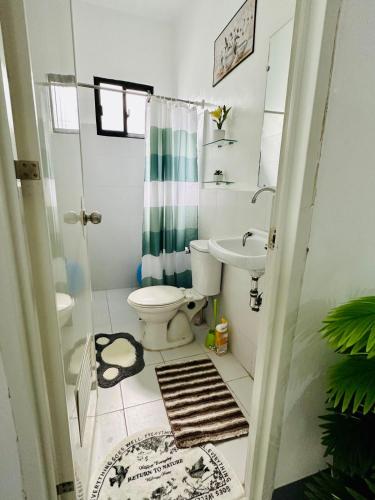 a bathroom with a toilet and a sink at Rai Staycation in Sampong