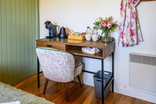 a desk in a room with a chair and flowers at Rose - Delightful Stables Conversion By STAE-Homes in Bristol