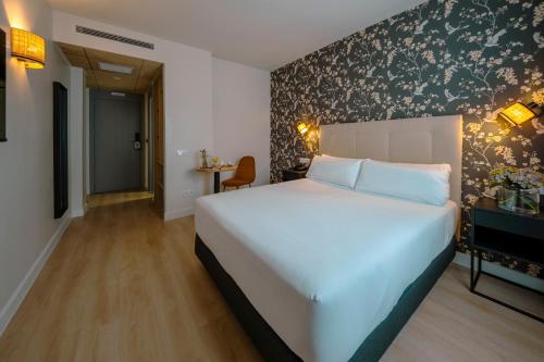 a bedroom with a large white bed in a room at Hotel Cisneros in Alcalá de Henares