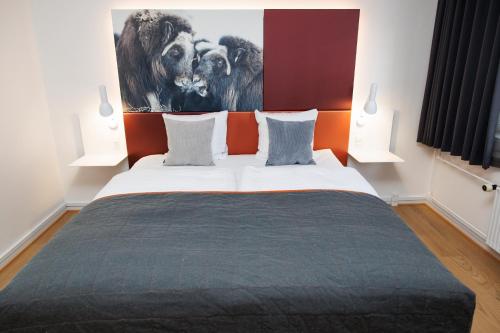 a bedroom with a bed with a painting on the wall at Hotel Hans Egede in Nuuk