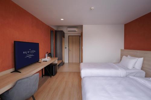 a hotel room with two beds and a flat screen tv at The Horizon Groove Hotel in Ban Khlong