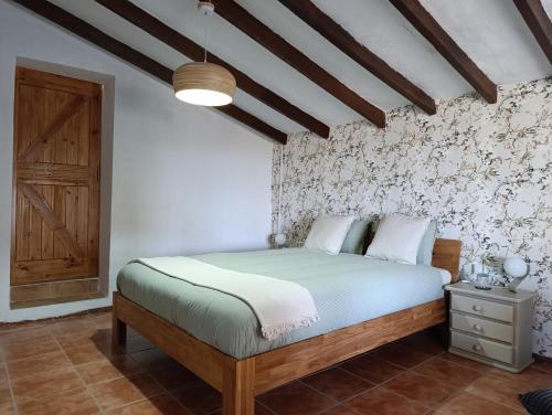 a bedroom with a bed and a wooden ceiling at CasaArabí in Arabí