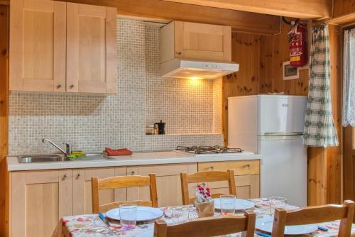 a kitchen with a table and chairs and a refrigerator at Le porte dell'agordino in Zenich