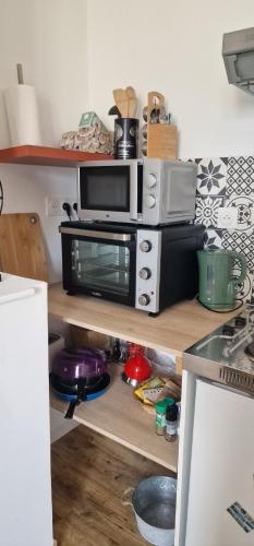 a kitchen with a microwave on top of a counter at APPART'HOTEL CASA Patricia in Béthune