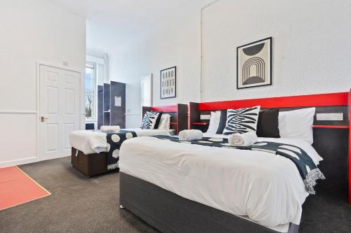 a bedroom with two beds and a red and white wall at Central Dudley Stay-Sleeps 3, Kitchen&Free Parking in Dudley