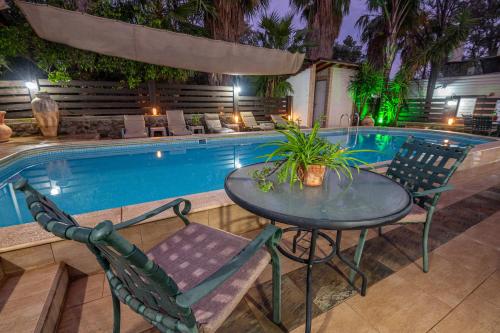 a table and chairs next to a pool at night at אביב בלב in Had Nes