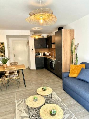 un salon avec un canapé bleu et une cuisine dans l'établissement T2 confort - résidence privée, à Propriano