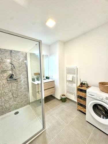 une salle de bain avec douche et machine à laver dans l'établissement T2 confort - résidence privée, à Propriano
