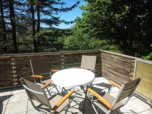 einen Tisch und Stühle auf einer Terrasse mit einem Zaun in der Unterkunft Hexenstube Morgana WLAN, tolles Bad und toller Balkon in Braunlage