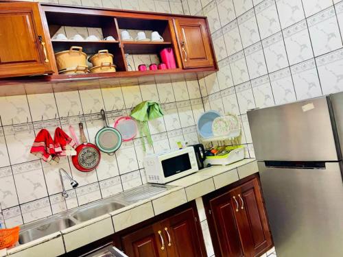 a kitchen counter with a sink and a microwave at EDEN Restorer in Yaoundé