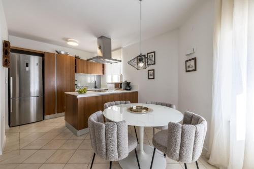 a kitchen with a white table and chairs at Villa Artea in Podstrana