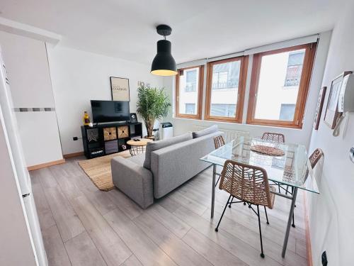 a living room with a couch and a glass table at Atuaire Home En la Plaza Mayor de Burgos Parking Incluido in Burgos