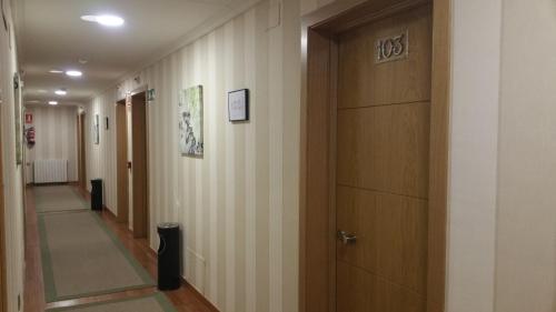 a corridor of a hallway with a door at Hotel Reina Isabel in Medina del Campo