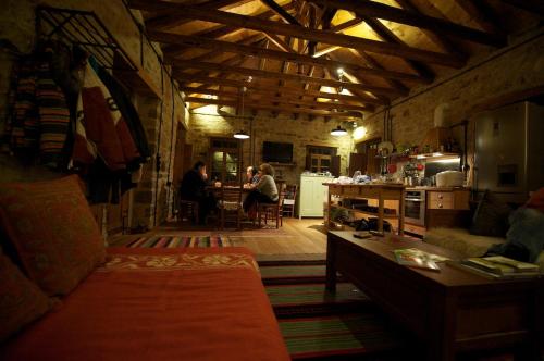 a living room with people sitting at a table at The Mountain House -mountain getaway in Sirako