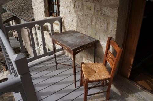a wooden table and a chair on a balcony at The Mountain House -mountain getaway in Sirako